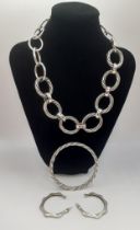 A small group of silver jewellery comprising a large hoop chain necklace, a silver twist bangle