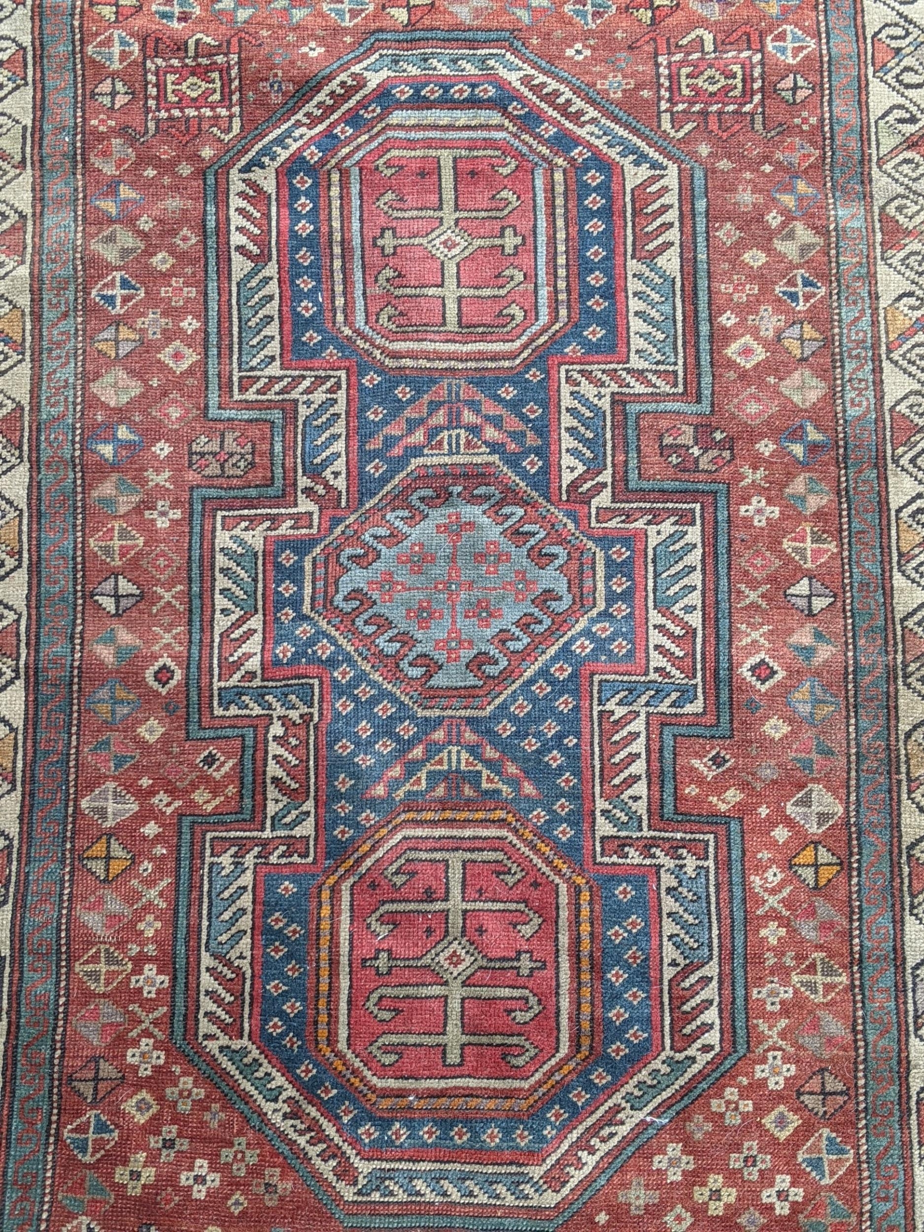 A Kazak rug decorated with symmetrical abstract motifs surrounded by quartered coloured geometric - Image 2 of 7