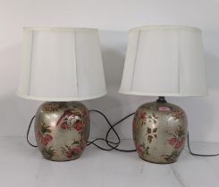 A pair of modern Oriental style table lamps decorated with parrots and floral decoration on a gold