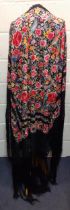 An early 20th century machine embroidered black Oriental shawl with vibrant images of roses, wild