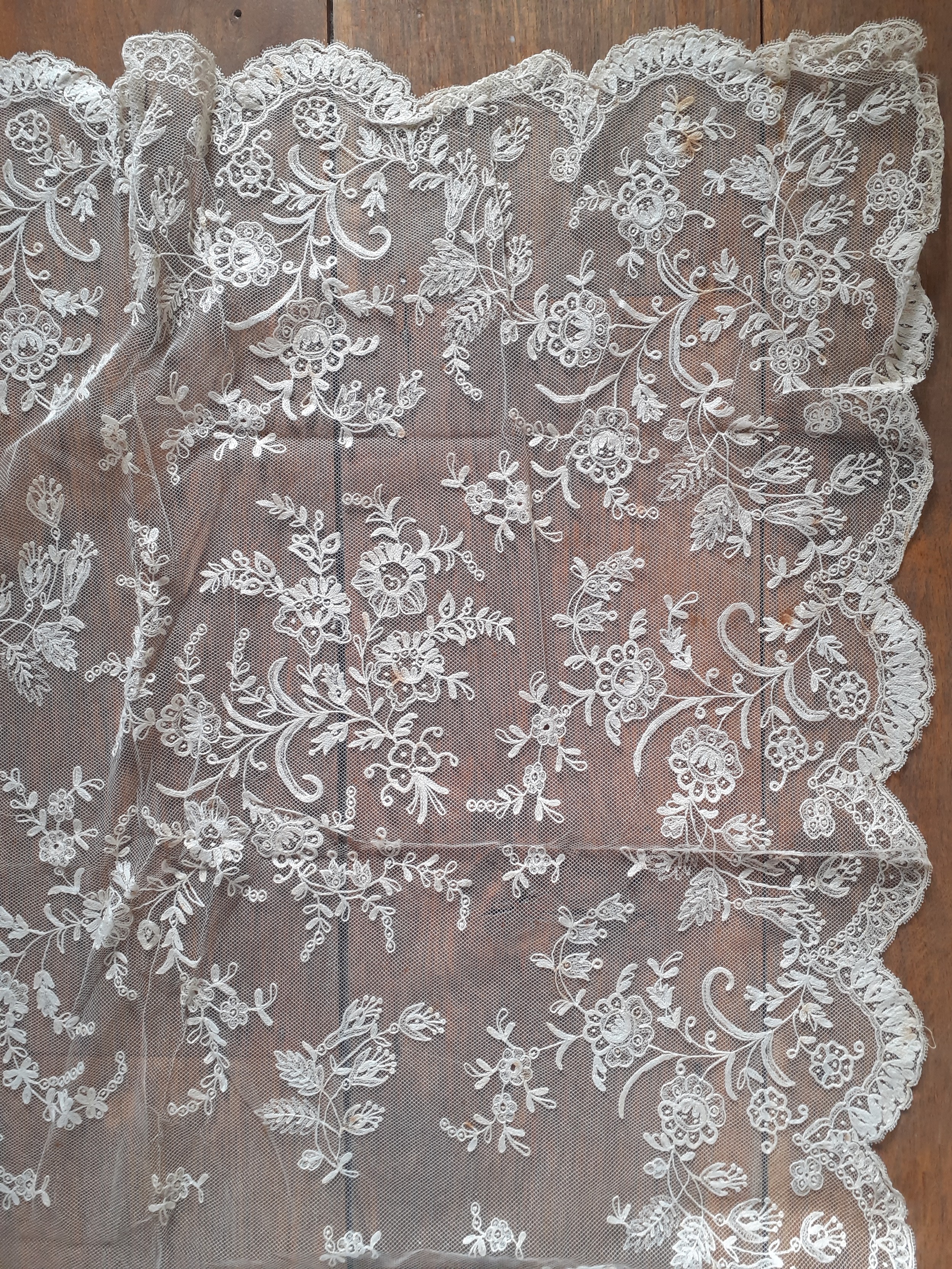 An Edwardian cream embroidered lace tablecloth A/F on button mesh ground with scalloped edges having - Image 2 of 9