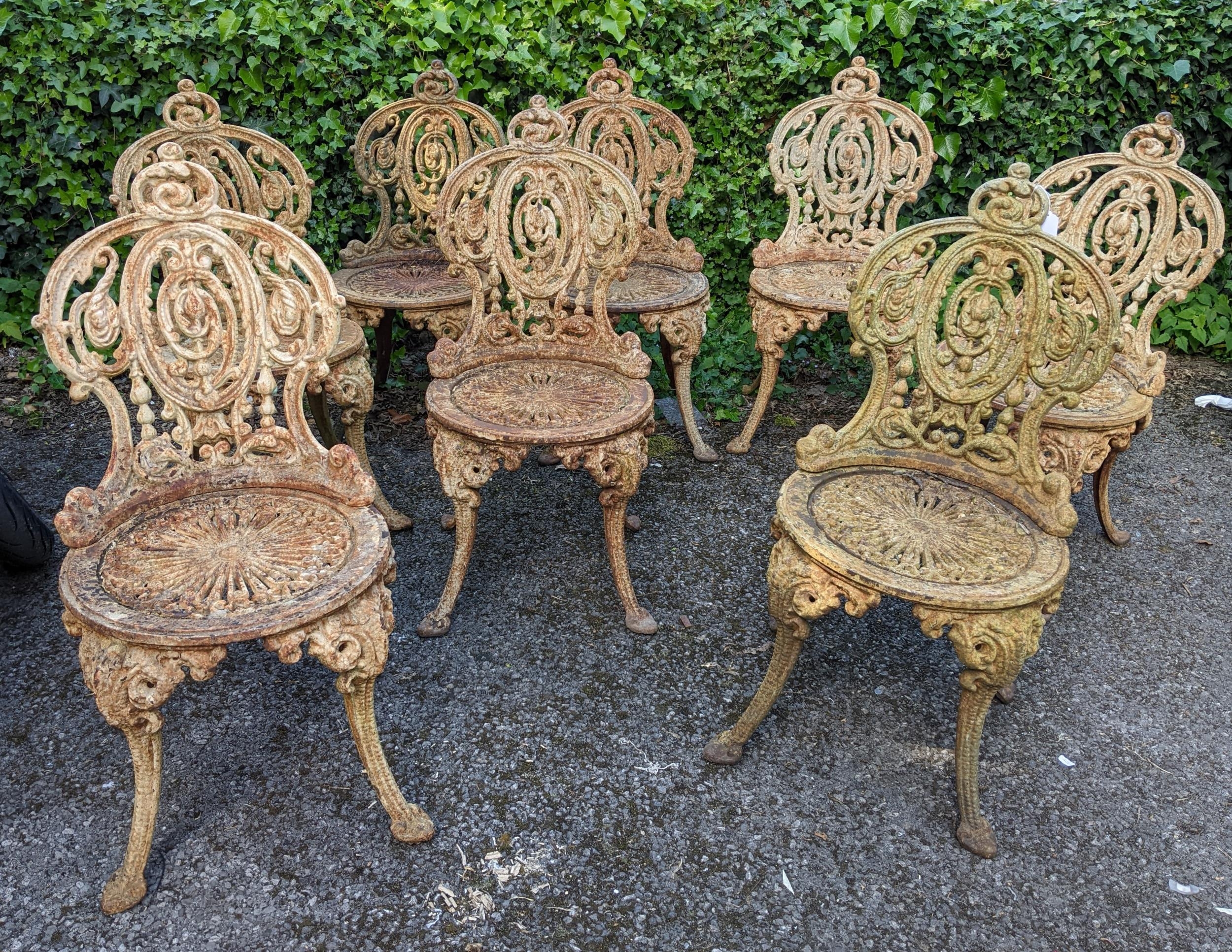 A set of eight Victorian pained cast iron garden chairs on splayed legs Location: If there is no