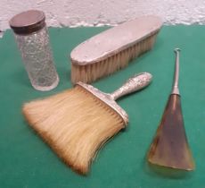 A Sterling silver handled brush and another, a silver topped glass dressing table pot and a button