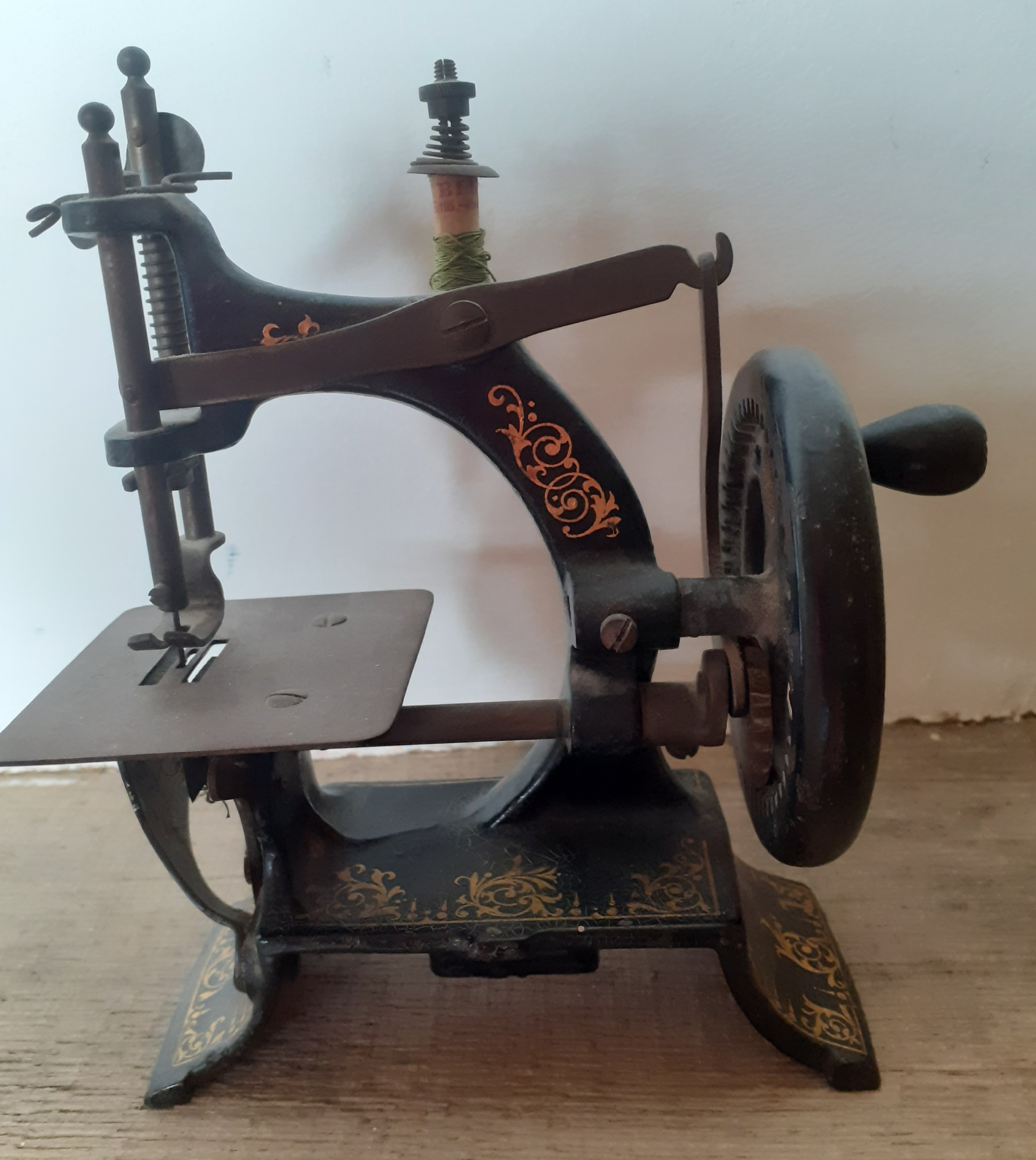 A small vintage toy cast iron hand cranked sewing machine 13cm wide x 17cm high. Location:R1.1 If