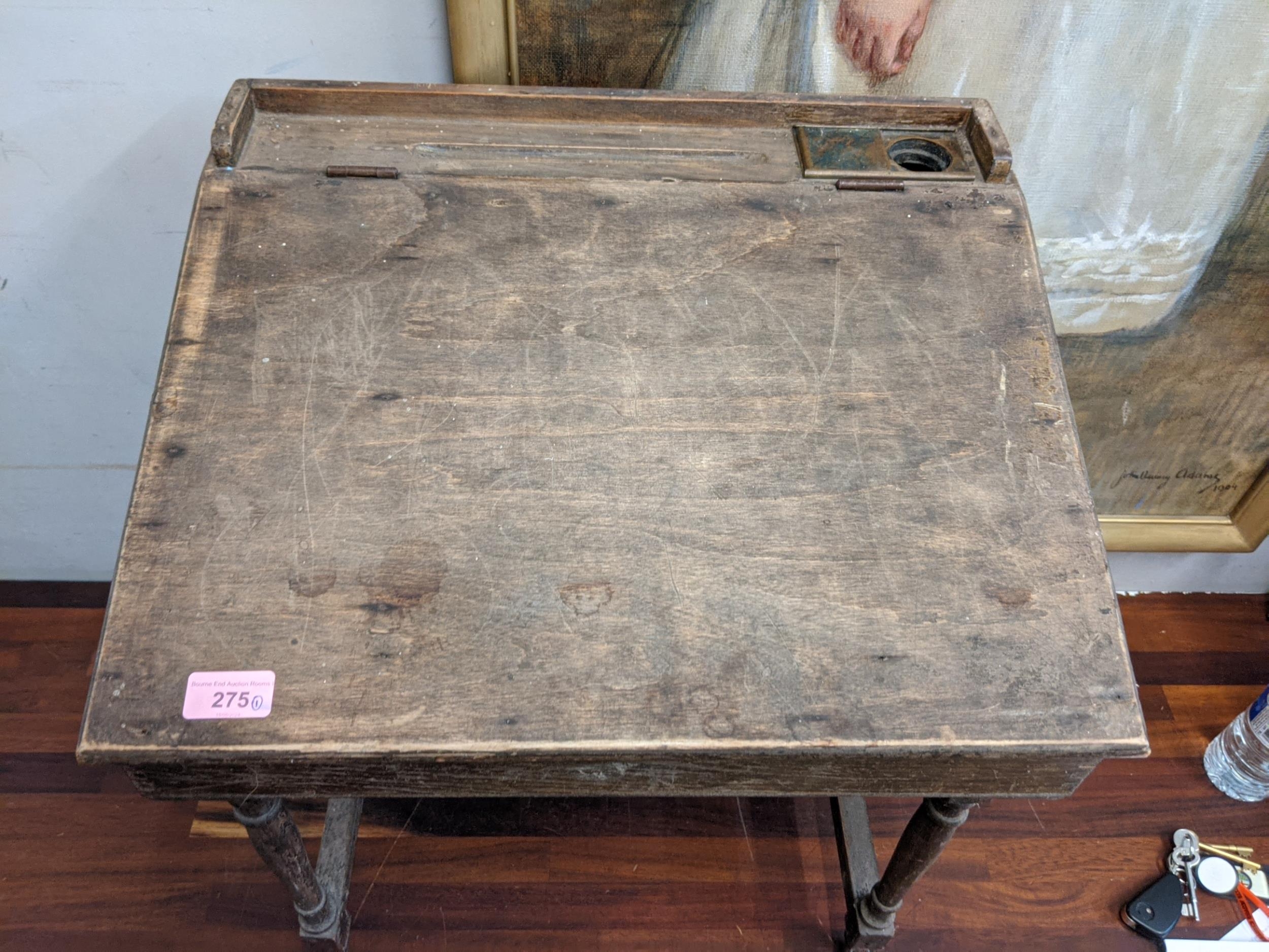 An early/mid 20th century child's desk with a hinged top, raised on tapered legs, united by a - Image 2 of 5