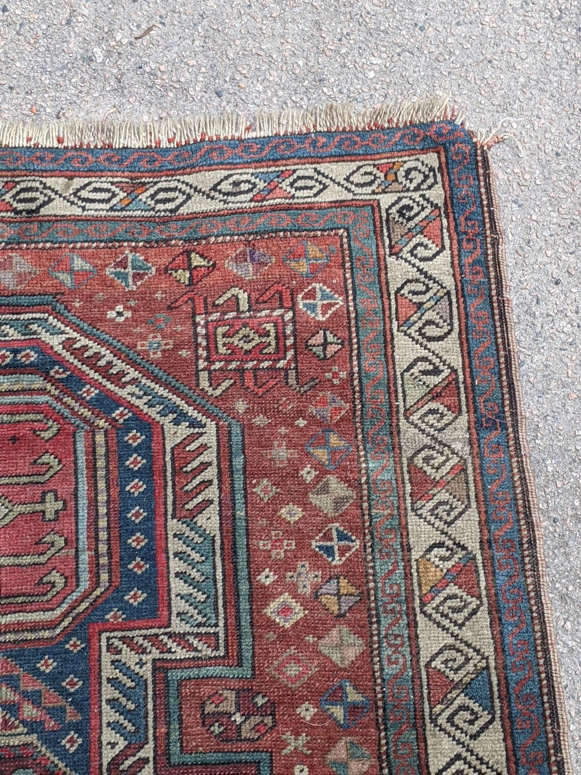 A Kazak rug decorated with symmetrical abstract motifs surrounded by quartered coloured geometric - Image 4 of 7