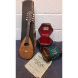 Two vintage musical instruments comprising a Napoli mandolin with music sheets and case A/F and a