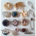 A collection of vintage brooches to include a Mexican silver Geisha face brooch, large Monet gold