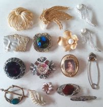 A collection of vintage brooches to include a Mexican silver Geisha face brooch, large Monet gold