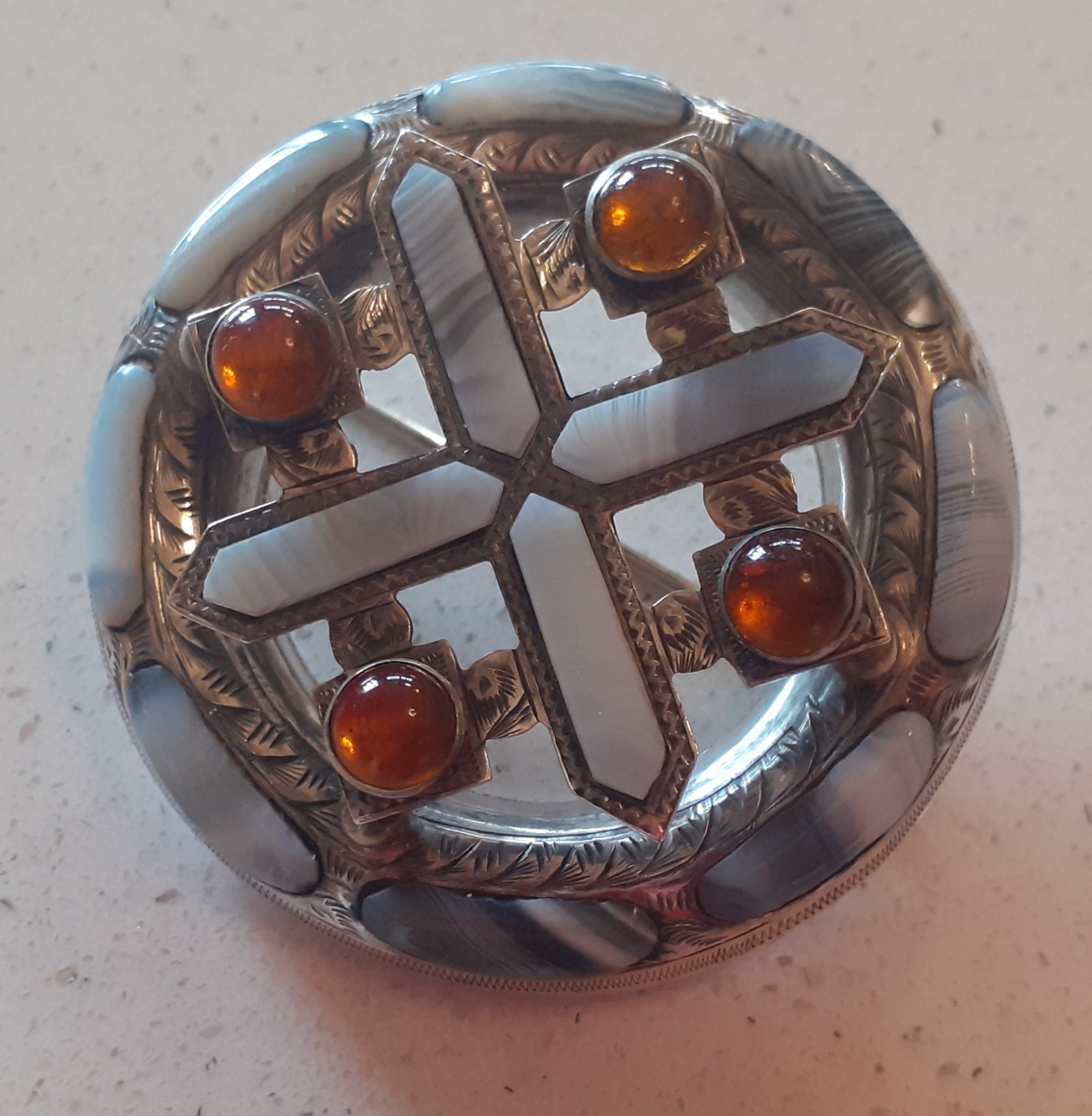 A silver tone brooch set with agate and coloured stones in the Scottish Celtic style. Location:Cab