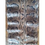 A vintage snakeskin roll measuring 180"x 17" (at widest point), probably python. Location: If