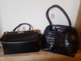 A late 20th Century black gladstone style handbag with gold tone hardware and key and a late 20th