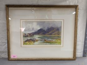 A watercolour depicting a Welsh mountain scene with rocks in the foreground, bearing signature '