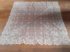 An Edwardian cream embroidered lace tablecloth A/F on button mesh ground with scalloped edges having