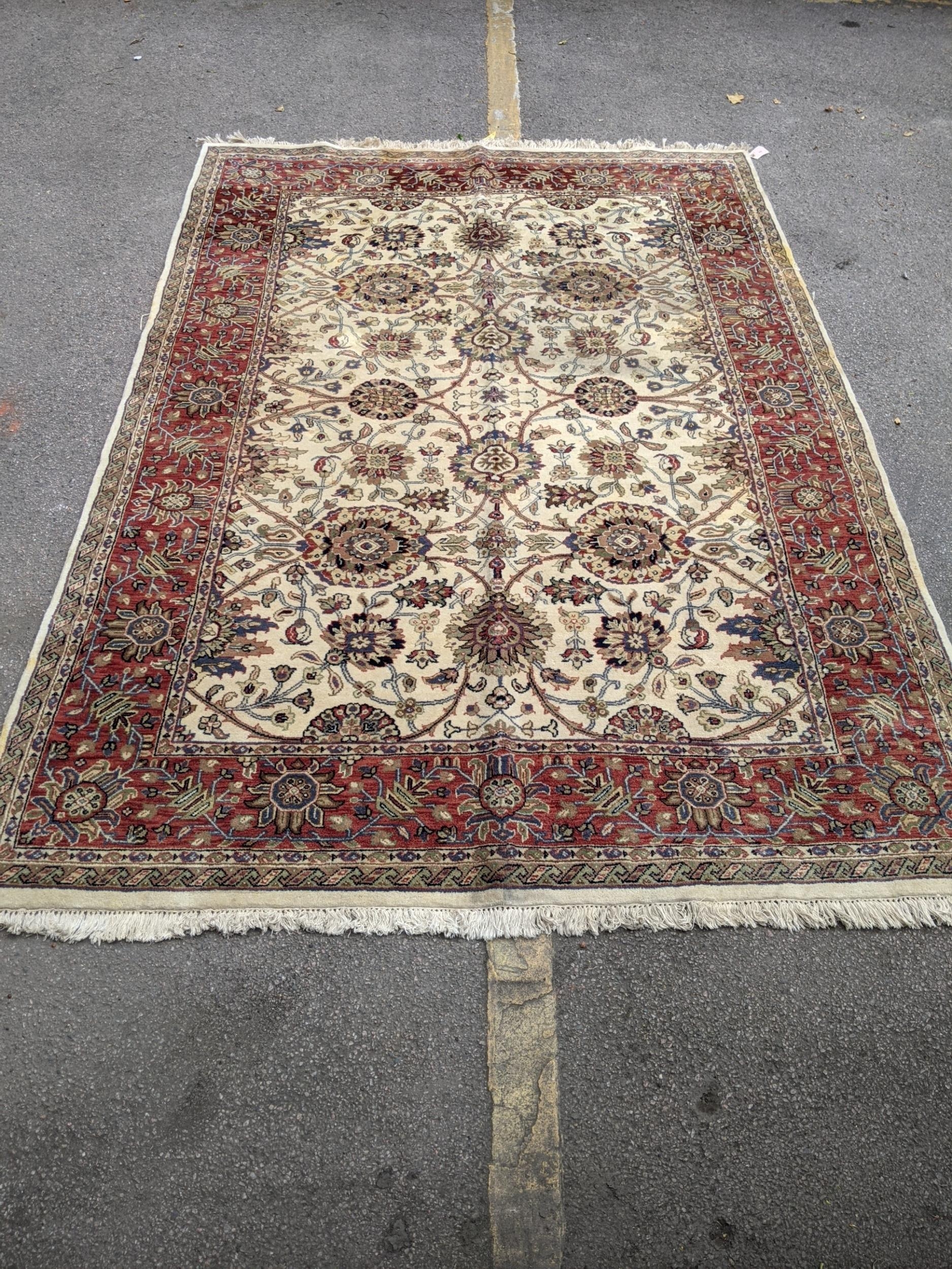 An antique Sharaen rug decorated symmetrically with four large medallions and four smaller ones on a