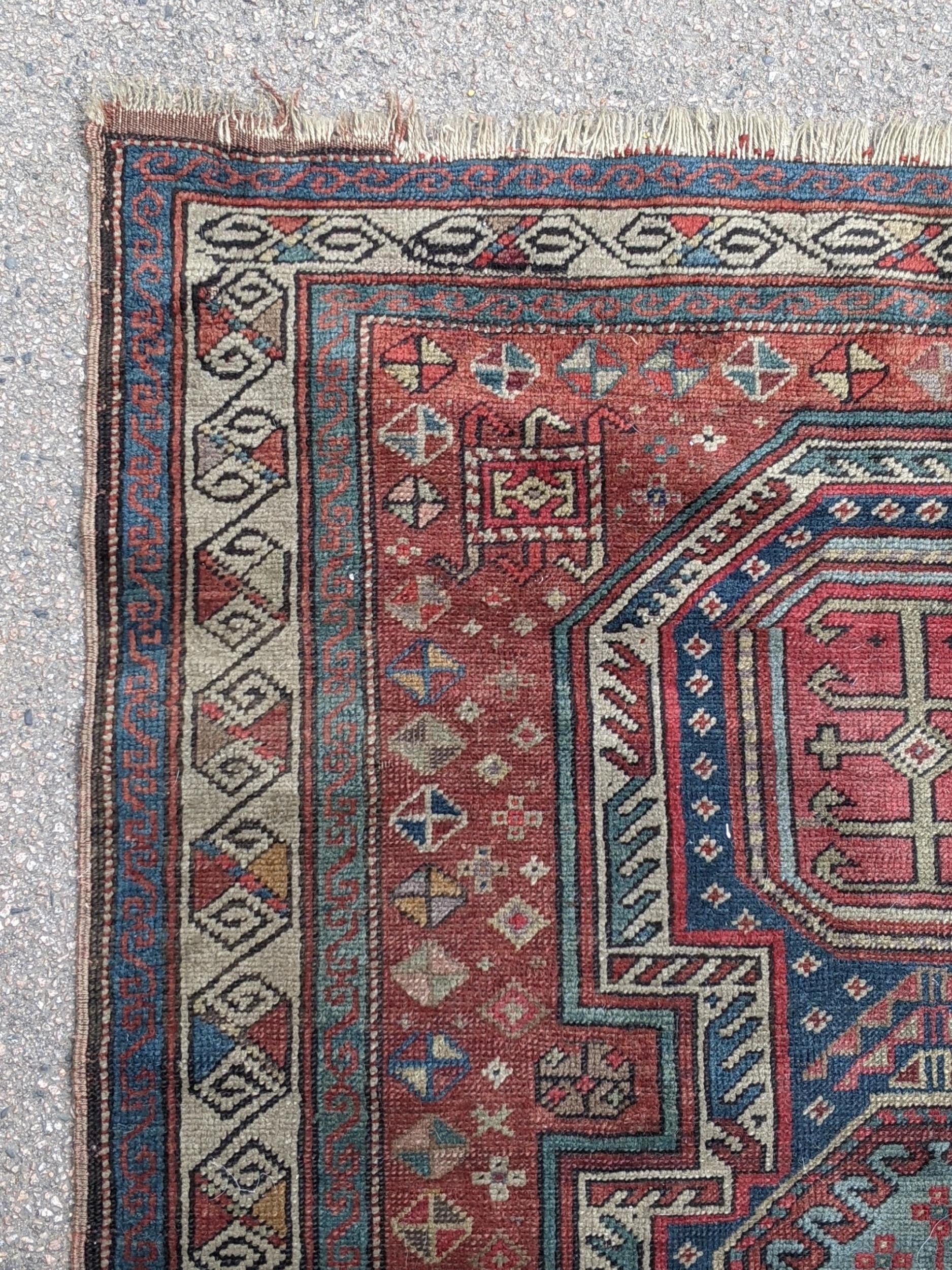 A Kazak rug decorated with symmetrical abstract motifs surrounded by quartered coloured geometric - Image 3 of 7