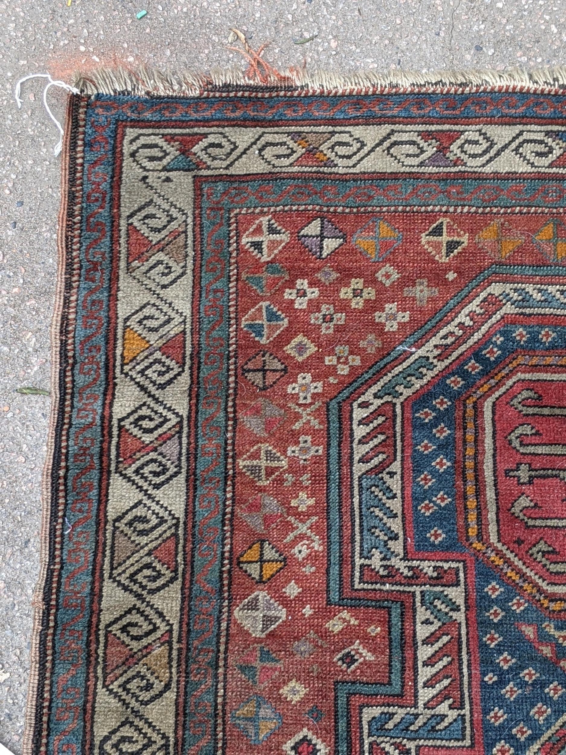A Kazak rug decorated with symmetrical abstract motifs surrounded by quartered coloured geometric - Image 5 of 7