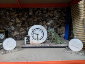 A French Art Deco marble and patinated spelter clock garniture set, the base mounted with a model of