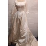 A 1961 cream silk wedding dress with ¾ sleeves, 28" waist x 36" chest, bow detail to rear waist with