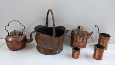 A selection of Victorian copper and brassware to include a graduating hanging cup measuring set,