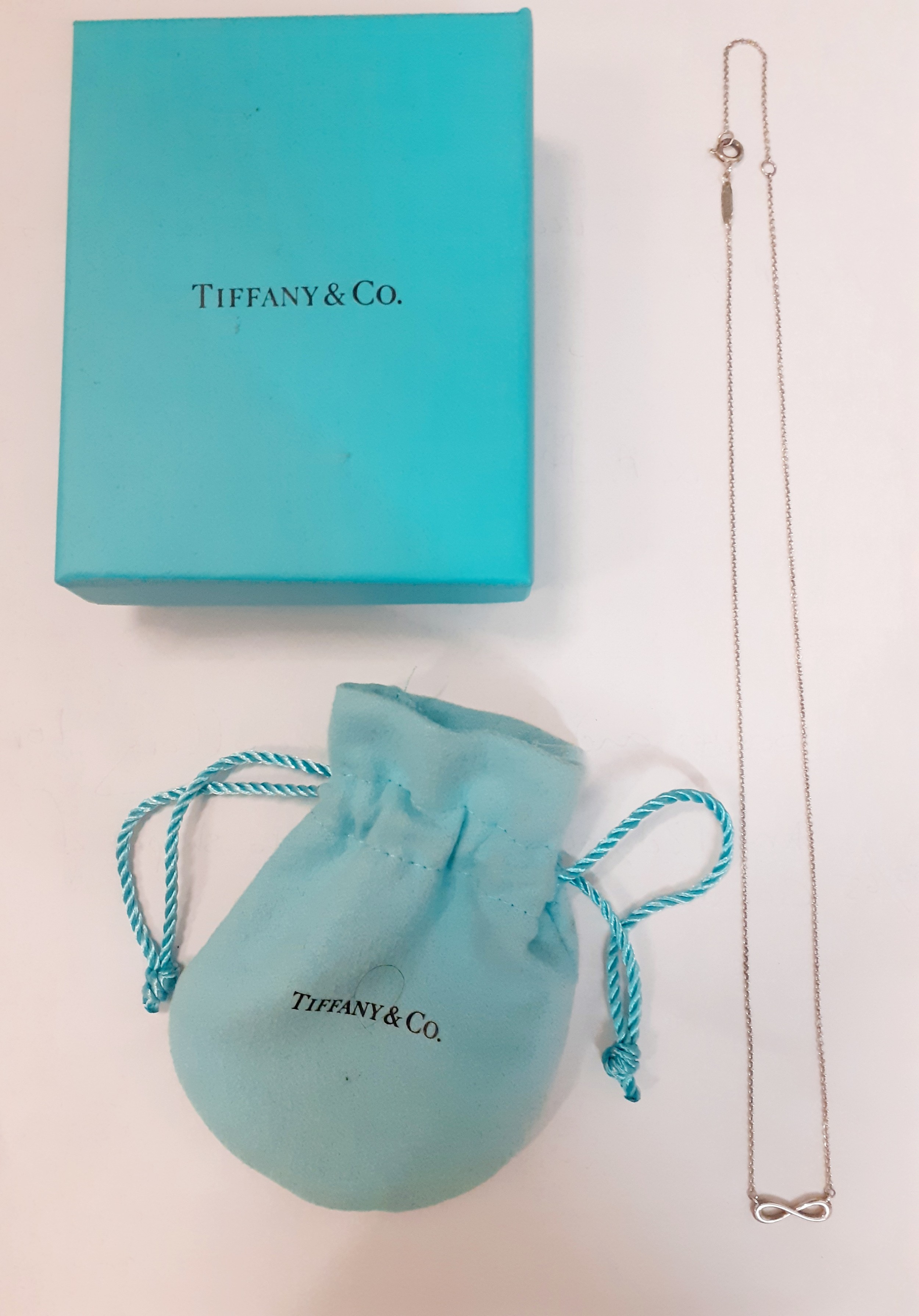 Tiffany & Co-A silver fine chain with infinity pendant, stamped 925, 1.55g together with a branded