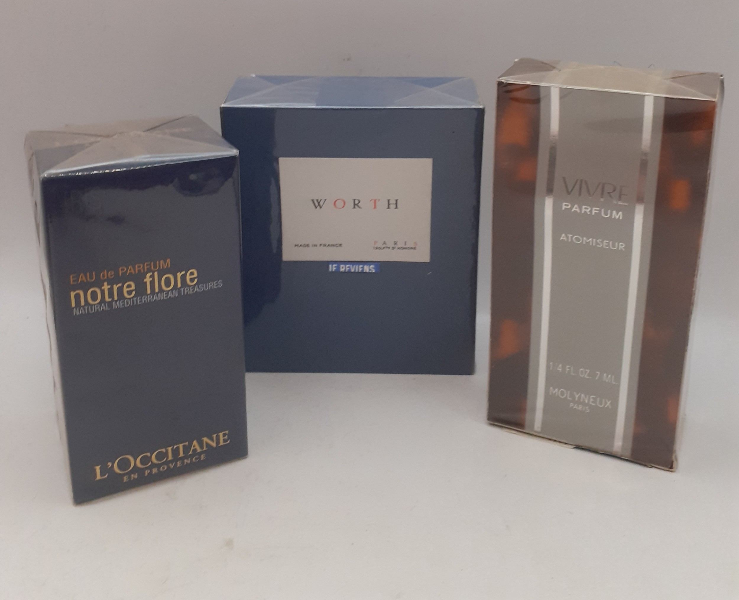 Three sealed fragrances comprising a bottle of L'Occitane Notre Flore Eau de Parfum 75ml, a bottle