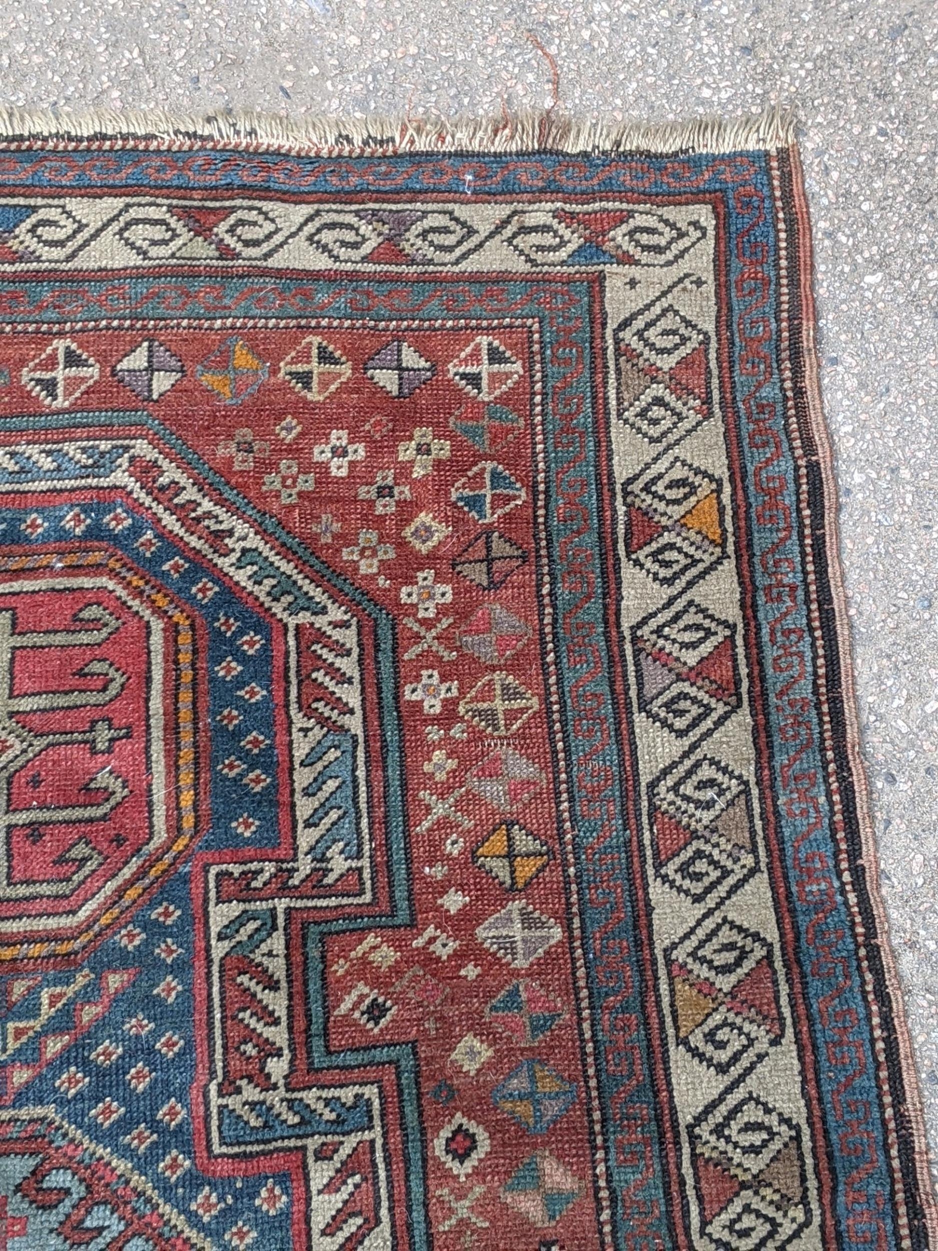 A Kazak rug decorated with symmetrical abstract motifs surrounded by quartered coloured geometric - Image 6 of 7