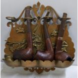 A brass hanging pipe rack containing three pipes, one with a 9ct gold band Location: If there is