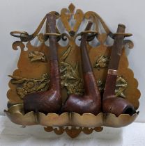 A brass hanging pipe rack containing three pipes, one with a 9ct gold band Location: If there is