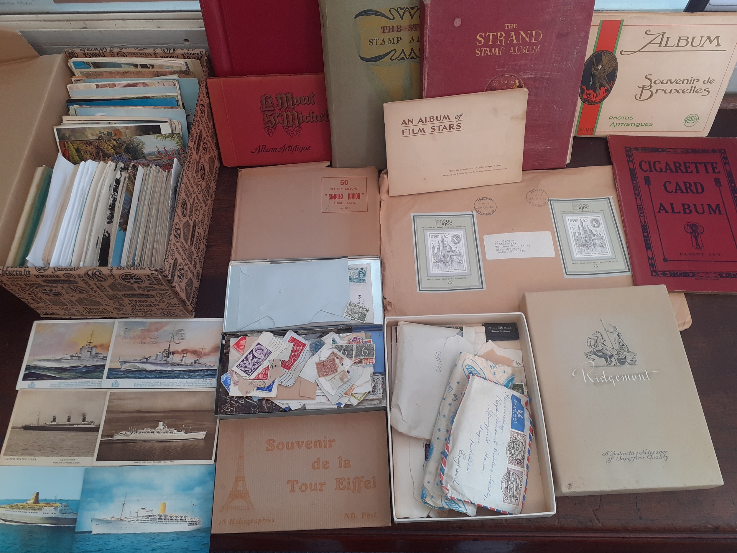 Three vintage partially filled stamp albums and loose stamps, vintage postcards to include steam