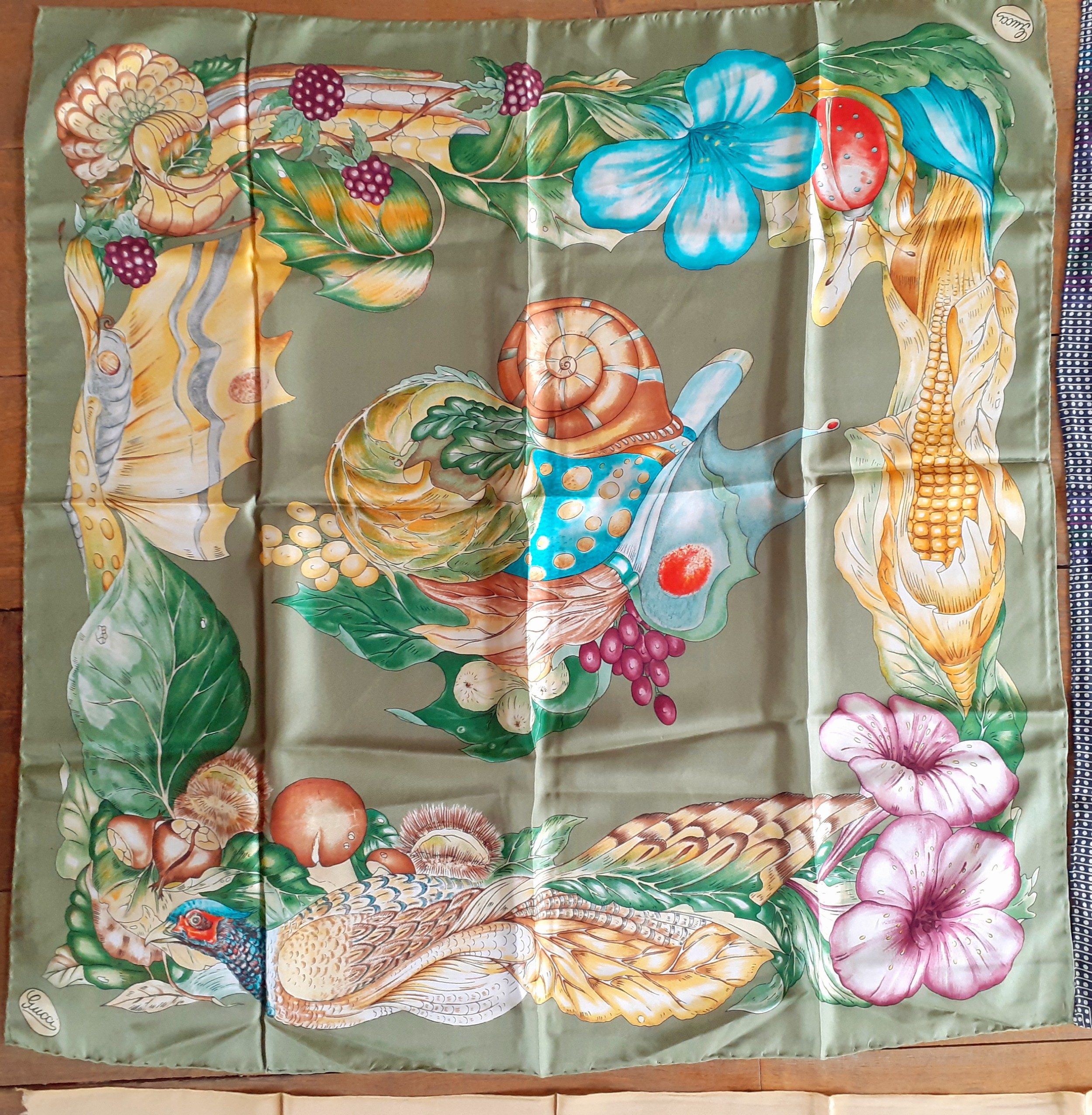 Gucci-A vintage Gucci silk scarf depicting images of a vegetable garden, game and insects on a green