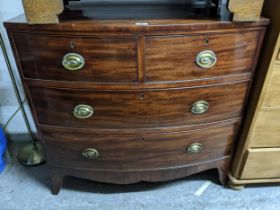An early 19th century bow fronted mahogany chest of two short and two long graduated drawers, shaped