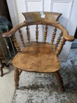 A late 19th century spindle back Captain's chair with solid seat on turned legs united by double H-