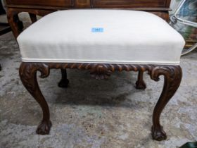 An early 20th century carved walnut upholstered stool, white fabric seat on carved cabriole legs and