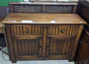 An early to mid oak linenfold sideboard, extended back with two panels of grape and vine leaf carved