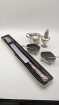 Silver to include a pepper pot, a pair of salts and a mustard pot, and a silver handled bread knife,