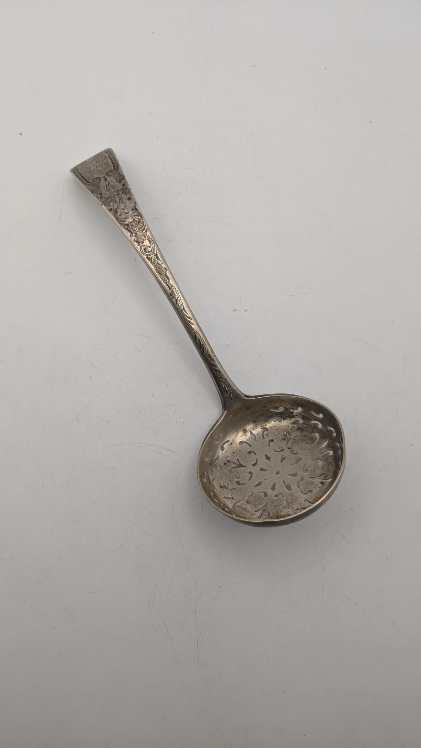 A silver sifter spoon with engraved and initiated ornament hallmarked London 1898, weight 50g