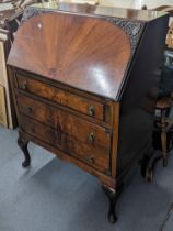 An early /mid 20th century Queen Anne style walnut bureau having a fall flap above three drawers,