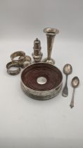 Mixed silver items to include a wine coaster, a tulip vase, three napkin rings, two teaspoons and