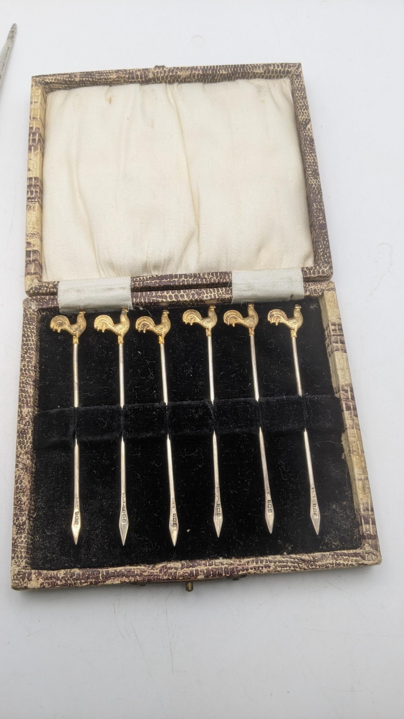 Silver to include six cocktail sticks in a fitted case, hallmarked London 1928, along with a meat - Image 2 of 3