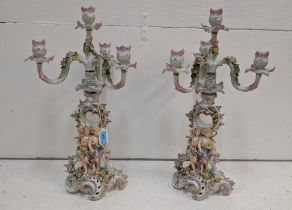 A pair of Sitzendorf four branch candelabras ornately decorated with flowering plants and gilt