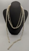 A triple strand pearl necklace with a silver and gilt clasp A/F and a single strand pearl necklace