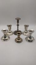 Two pairs of silver dwarf candlesticks, a taper style stick and another Location: If there is no