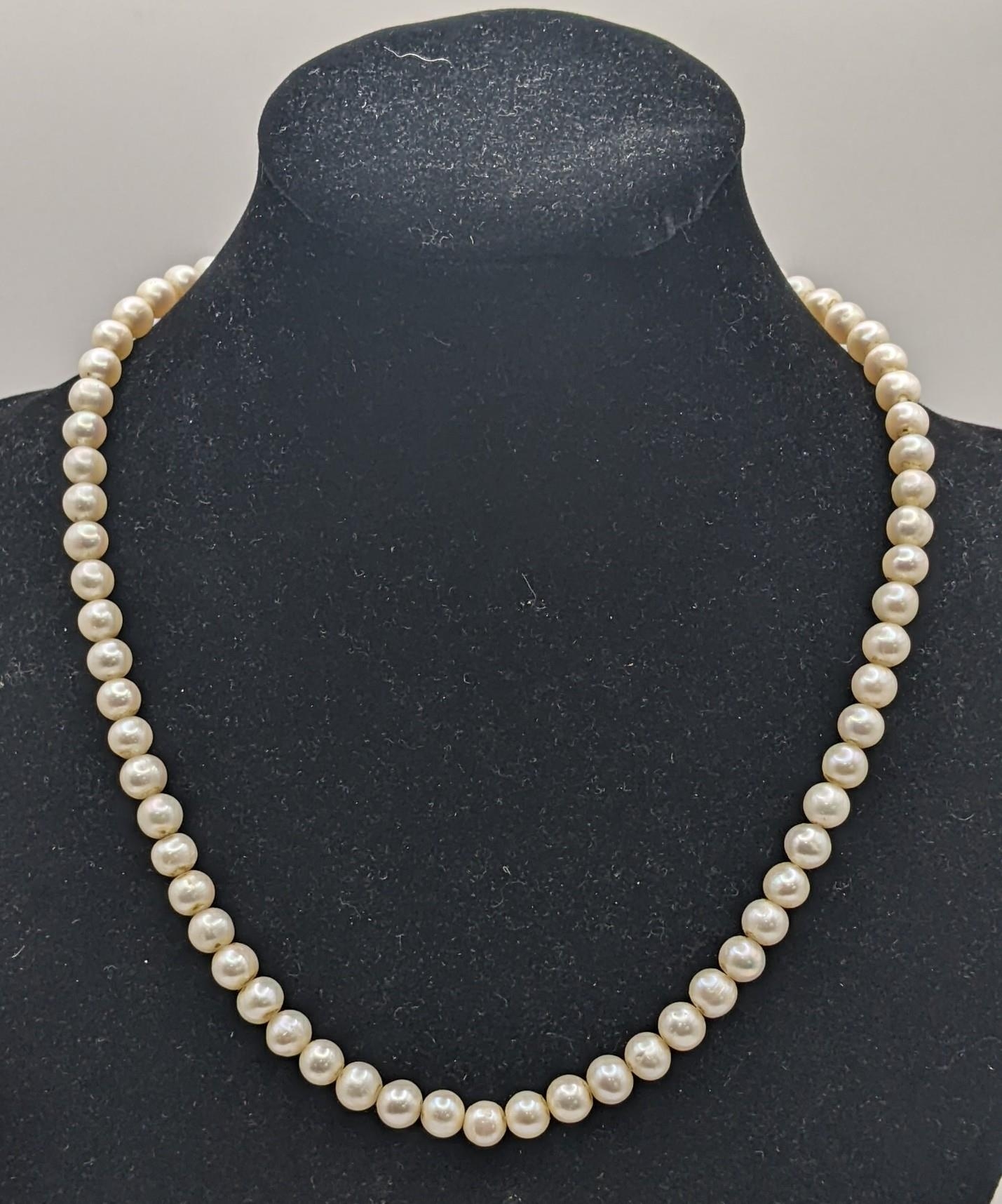 A yellow gold and cultured pearl single strand necklace with a bolt ring clasp, unmarked but tests