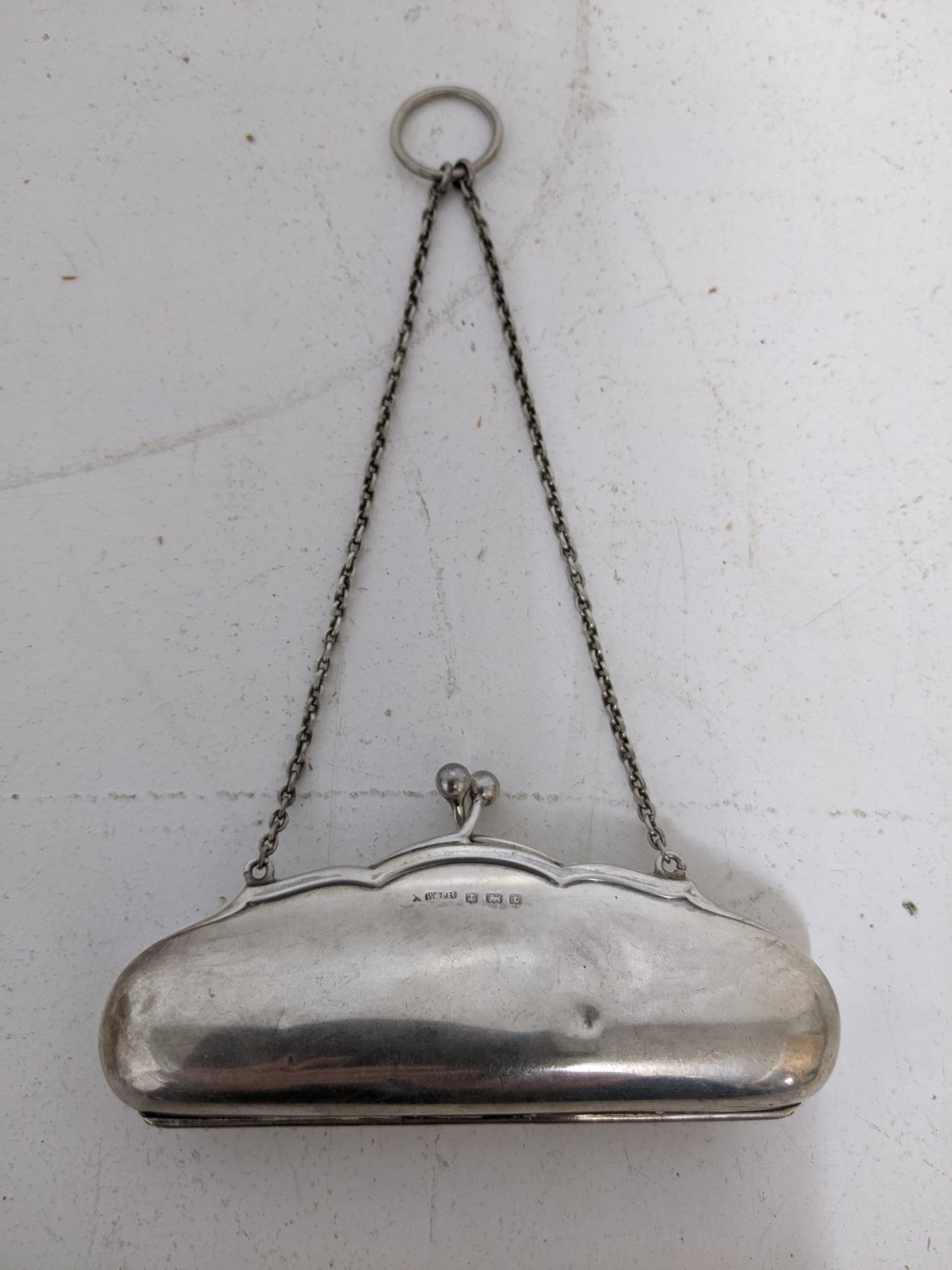 A George V silver ladies purse with leather fitted interior on a chain and suspension ring,