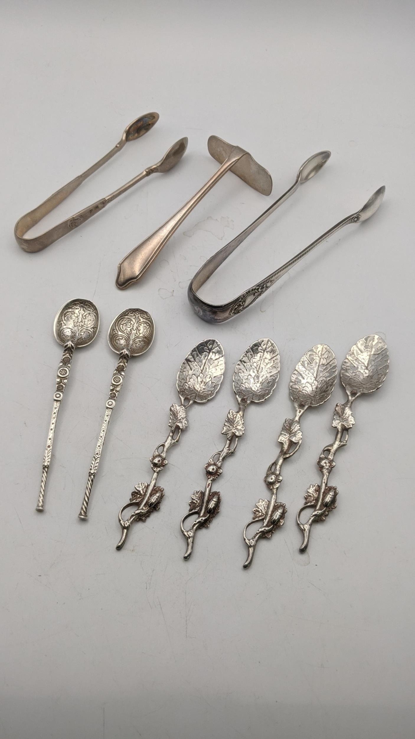 Two pairs of sugar tongs, a silver pusher, a pair of decorative coffee spoons and four white metal - Image 2 of 2