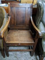 A 20th century reproduction oak open armchair, panelled back, scrolled end arms on square