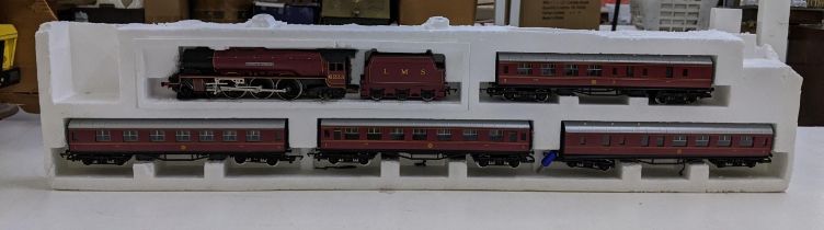 A Hornby 00 gauge Duchess of Sutherland model locomotive and three carriages, in some of its