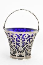 A late 19th/early 20th century silver small basket, marks rubbed, having a blue glass liner, rope
