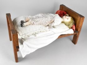A Mid 20th Century Wooden Dolls Bed Complete with Ceramic Faced Doll, Bed 59x30cms High